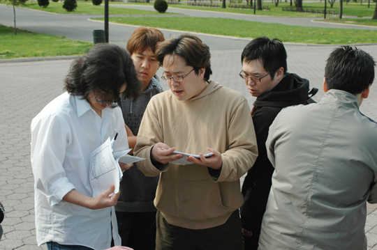 스토리보드를 정검중인 진영규 감독(왼쪽)과 회원들 